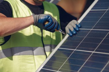 Man in a white helmet near a solar panel Engineer in a white helmet. Man near solar panel.