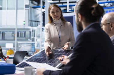 Solar panels plant managers brainstorming steps to take in reducing downtime Solar panels manufacturing plant managers brainstorming steps to take in reducing downtime. Photovoltaics factory management taking notes of upgrades to make after diagnosing malfunctioning systems